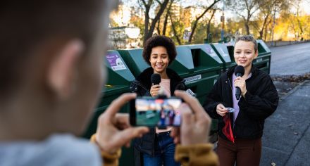 Två unga reportrar blir filmade vid en återvinningsstation